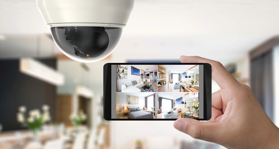 Homeowner holding smartphone with video feed from security cameras in Washington, DC